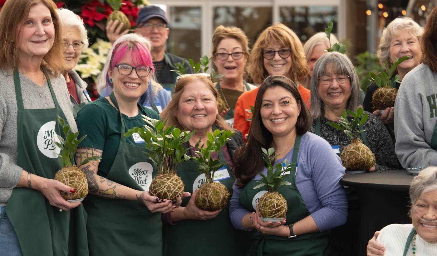 A workshop group holding the kokedama they each built